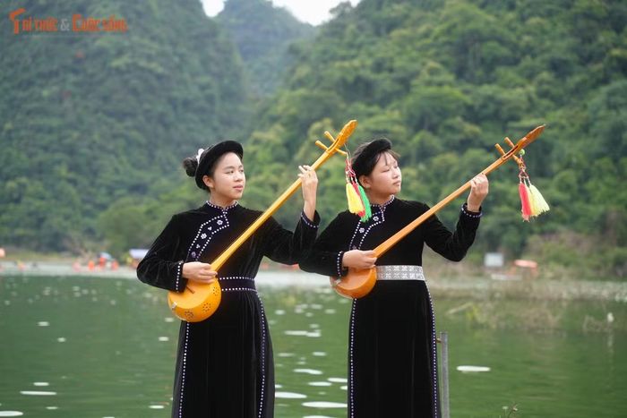 Cô bé Ngọc Bích (15 tuổi - bên trái) ôm chiếc đàn Tính gảy lên những giai điệu Then tha thiết ngay trên chiếc bè tre giữa thung lũng Đồng Lâm.