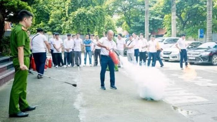 Cán bộ, công nhân viên cơ sở tham gia thực hành sử dụng bình chữa cháy xách tay