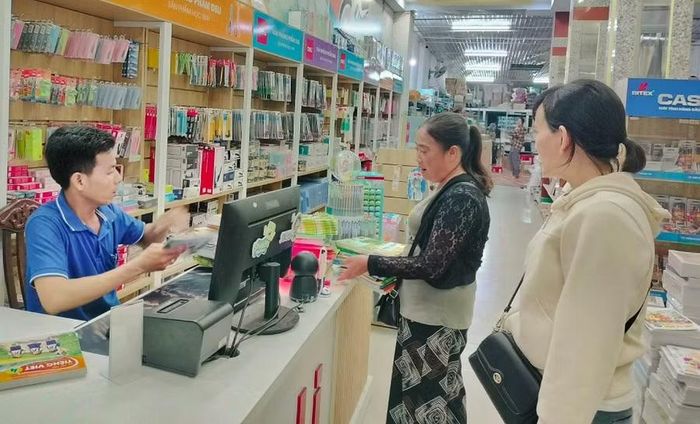 Phụ huynh đến cửa hàng tìm mua sách giáo khoa cho con.
