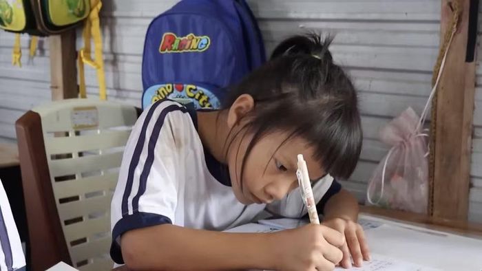Dù có đi làm cùng mẹ tới khuya, hôm sau các em vẫn cố gắng làm bài tập đầy đủ. Ảnh: Phương Thy.