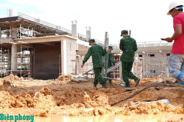 Cán bộ, chiến sĩ Đồn Biên phòng cửa khẩu Chi Ma phối hợp vận chuyển giàn giáo, cột chống và vật liệu xây dựng phục vụ hoàn thiện các hạng mục của trường. Ảnh: Thu Hiền