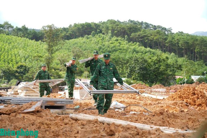 Sau nhiều ngày mưa, mặt bằng công trường lầy lội, cán bộ, chiến sĩ Đồn Biên phòng cửa khẩu Chi Ma vẫn tích cực hỗ trợ vận chuyển vật liệu đến các vị trí thi công. Ảnh: Khánh Chi