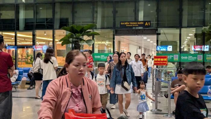 Hành khách xuống máy bay ở sân bay Tân Sơn Nhất tối qua. Ảnh: Hữu Huy.
