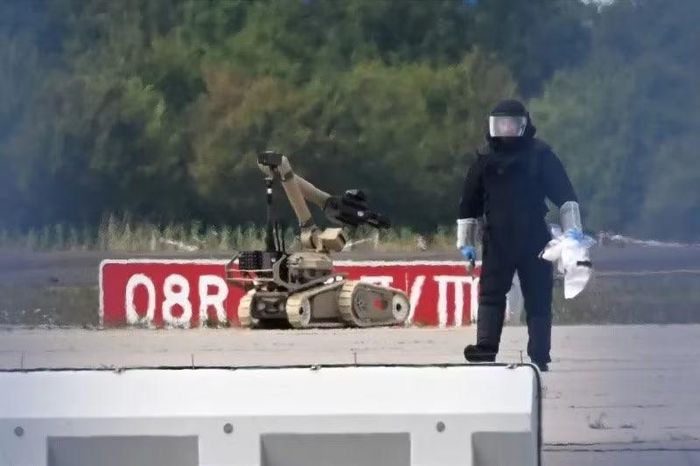 Kỹ thuật viên làm việc cùng robot xử lý bom gần máy bay Ukraine tại sân bay Leipzig/Halle của Đức, nơi người ta tìm thấy một UAV có thiết bị nổ ngày 5/8/2026. Ảnh: DPA.