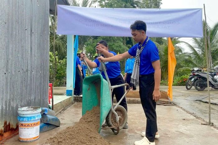 Đoàn viên, sinh viên tình nguyện tham gia xây dựng Nhà Khăn quàng đỏ tặng gia đình em Trịnh Triều Phát.