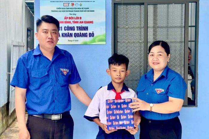 Chị Thị Phương Hồng - Phó Bí thư Thường trực Tỉnh Đoàn và anh Nguyễn Hoàng Khang - Bí thư Đoàn Thanh niên xã Vĩnh Bình tặng quà cho em Trịnh Triều Phát.