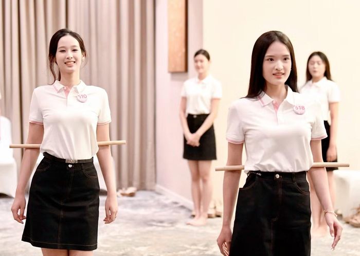 Một bài tập khác cũng gây chú ý là kẹp gậy phía sau lưng khi catwalk. Với dụng cụ này, các cô gái được hướng dẫn cách kiểm soát cánh tay, tránh tình trạng đánh tay quá rộng hoặc thiếu tự nhiên khi di chuyển.