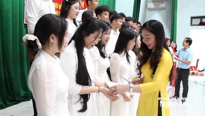 Đồng chí Nguyễn Thị Hà - Phó Bí thư thường trực Đảng uỷ xã Quỳnh Anh trao quà cho các đảng viên mới và quần chúng ưu tú chuẩn bị kết nạp Đảng. Ảnh: Hồng Diện