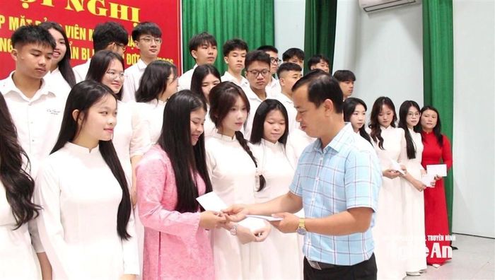 Đồng chí Nguyễn Văn Thưởng - Bí thư Đảng ủy xã Quỳnh Anh trao quà cho các đảng viên mới và quần chúng ưu tú chuẩn bị kết nạp Đảng. Ảnh: Hồng Diện