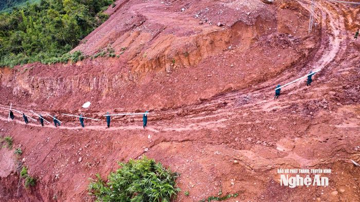 Lực lượng vũ trang hỗ trợ đơn vị thi công vận chuyển vật tư lên công trình. Ảnh: Thành Cường