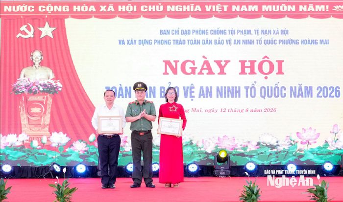 Giám đốc Công an tỉnh Thiếu tướng Đinh Việt Dũng tặng Giấy khen cho đại diện Trường THPT Hoàng Mai và Chủ tịch UBND phường Hoàng Mai Phạm Văn Hào. Ảnh: Phạm Bằng