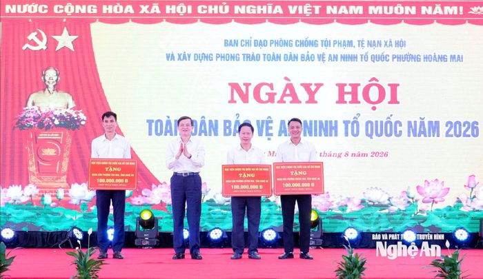 Đồng chí Đoàn Minh Huấn - Ủy viên Bộ Chính trị, Giám đốc Học viện Chính trị quốc gia Hồ Chí Minh tặng quà cho 3 phường: Hoàng Mai, Tân Mai, Quỳnh Mai. Ảnh: Phạm Bằng