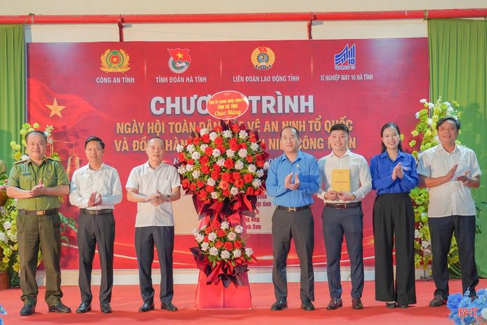 Các đại biểu tặng hoa chúc mừng "Ngày hội toàn dân bảo vệ ANTQ" tại Xí nghiệp May 10 Hà Tĩnh.