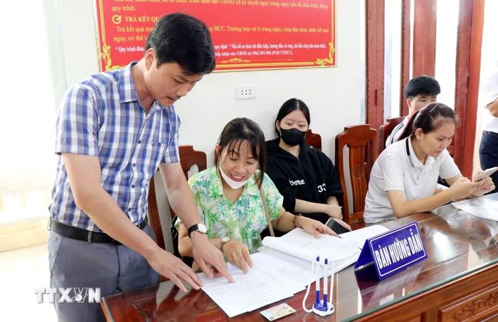 Cán bộ Trung tâm phục vụ hành chính công xã Quỹ Nhất, tỉnh Ninh Bình hướng dẫn người dân thực hiện các thủ tục hành chính. (Ảnh: Nguyễn Lành/TTXVN)