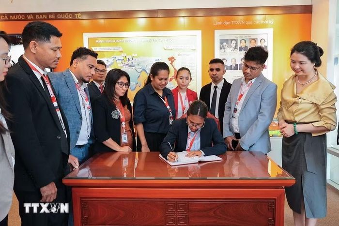 Đoàn đại biểu Timor-Leste tham quan và ghi sổ lưu niệm tại Phòng truyền thống TTXVN. (Ảnh: Lê Đông/TTXVN)