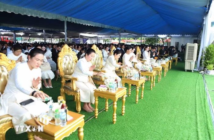 Đại biểu thực hiện nghi thức nhỏ giọt nước tích đức tại Lễ truy điệu và an táng cấp Nhà nước đồng chí Xaysomphone Phomvihane. (Ảnh: Xuân Tú/TTXVN)