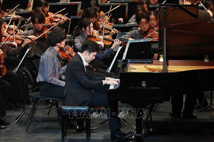 Nghệ sĩ piano trẻ Lingfei Stephan Xie biểu diễn cùng các nghệ sĩ trong chương trình. Ảnh: TTXVN phát