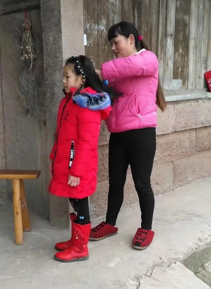 Dì Yi, người hàng xóm, chải tóc cho Trương Chính. (Ảnh do người được phỏng vấn cung cấp)