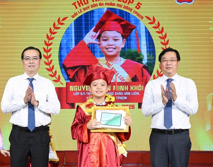 Ông Lê Quốc Phong và ông Lê Văn Minh trao thưởng cho em Nguyễn Trần Minh Khôi (lớp 5/1, Trường TH Châu Văn Liêm, phường Bình Tây, TPHCM), Thủ khoa khối lớp 5 Giải Lê Quý Đôn trên ấn phẩm Nhi Đồng TPHCM. Ảnh: VIỆT DŨNG