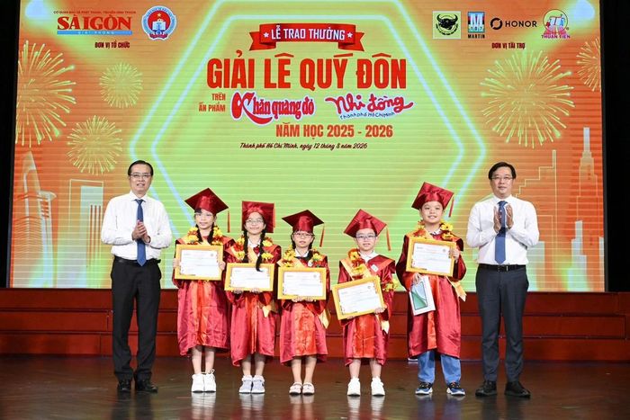 Ông Lê Quốc Phong (Ủy viên Trung ương Đảng, Phó Bí thư Thường trực Thành ủy TPHCM) và ông Lê Văn Minh (Tổng Giám đốc Cơ quan Báo và Phát thanh, Truyền hình TPHCM) trao thưởng cho các thí sinh đoạt Giải Thủ khoa Giải Lê Quý Đôn trên ấn phẩm Nhi Đồng TPHCM. Ảnh: VIỆT DŨNG