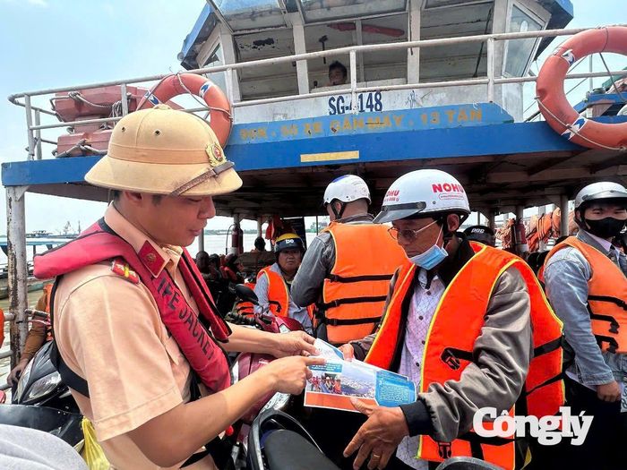Phát tờ rơi tuyên truyền pháp luật cho hành khách tại bến đò Phú Xuân - Phước Khánh.