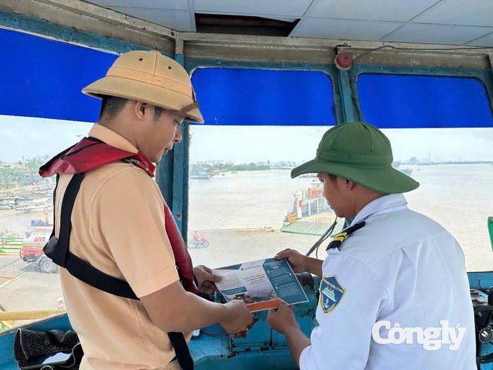 Cán bộ Trạm Cảnh sát đường thủy Phú Xuân phát tờ rơi tuyên truyền pháp luật cho thuyền trưởng, thuyền viên và hành khách tại bến phà Bình Khánh.