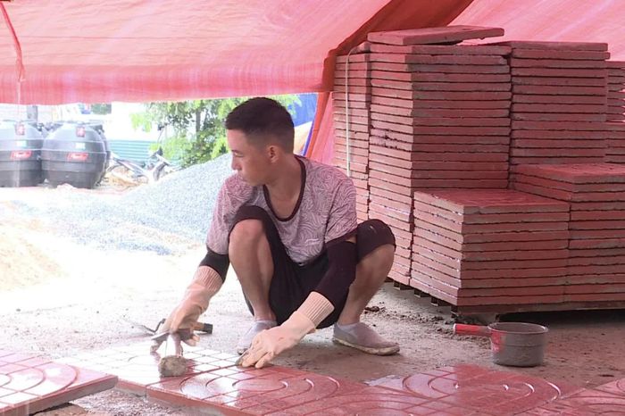 Công nhân lát nền sân trường trong thời tiết mưa gió.