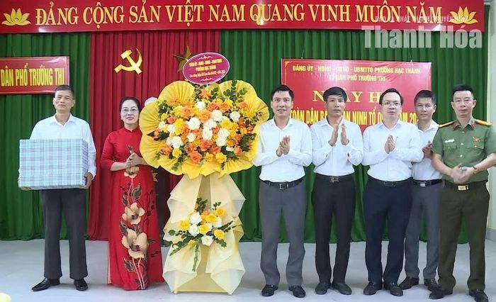 Bí thư Đảng ủy, Chủ tịch HĐND phường Hạc Thành Nguyễn Văn Biện trao lẵng hoa chúc mừng Nhân dân và cán bộ tổ dân phố Trường Thi.