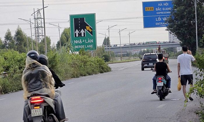  Nhiều người điều khiển xe máy vẫn đi vào cao tốc dù đã có biển cấm. Ảnh chụp tại ngã ba Đồng Vàng, lối vào cao tốc đoạn qua phường Nếnh chiều tối 9/8. 
