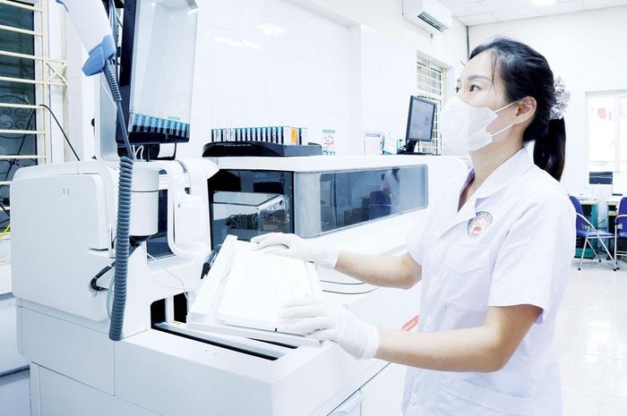 Bác sĩ trẻ Bệnh viện Đa khoa Từ Sơn vận hành máy xét nghiệm sinh hóa tự động.