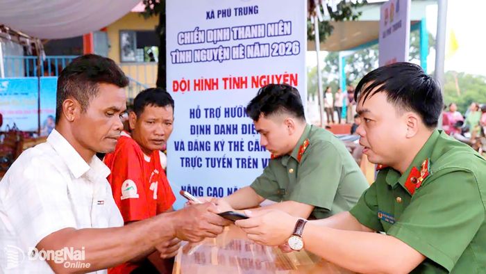 Công an xã Phú Trung và đoàn viên thanh niên xã hướng dẫn người dân cài đặt VneID và kích hoạt định danh điện tử. Ảnh: CTV