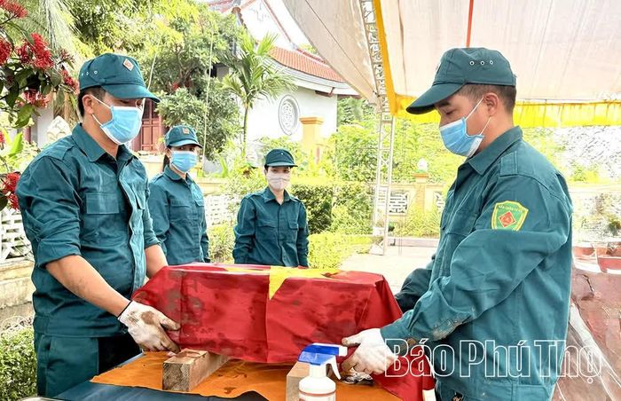 Dân quân tự vệ xã Vĩnh Phú di chuyển phần hài cốt hỗ trợ lực lượng lấy mẫu ADN hài cốt liệt sĩ.
