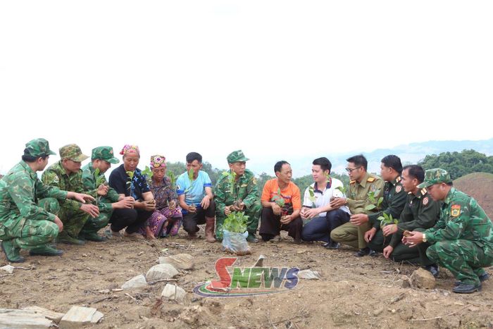 Cán bộ Đồn Biên phòng Chiềng Tương hướng dẫn nhân dân bản Móng Nặm (nước CHDCND Lào) kỹ thuật chăm sóc cây cà phê.