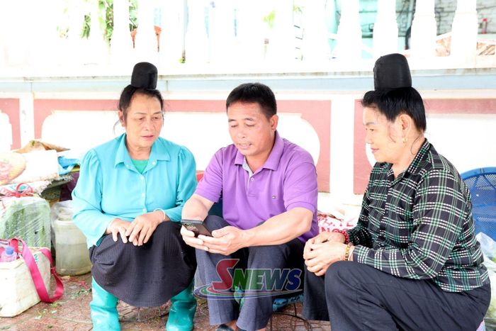 Tổ công nghệ số cộng đồng hướng dẫn tiểu thương chợ Chiềng Mung cài đặt mã QR thanh toán.