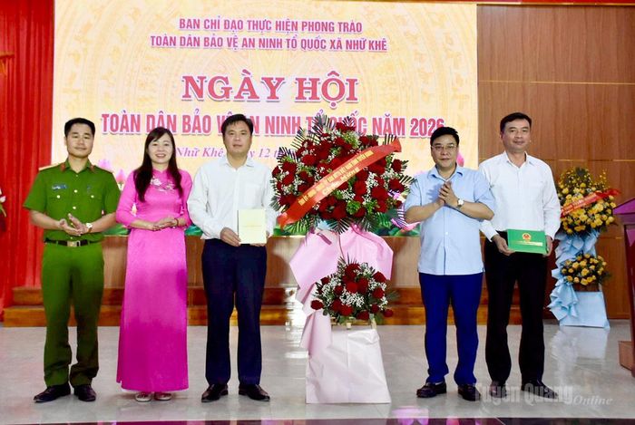 Đồng chí Hoàng Gia Long, Ủy viên Ban Thường vụ Tỉnh ủy, Phó Chủ tịch UBND tỉnh tặng hoa chúc mừng Ngày hội Toàn dân bảo vệ an ninh Tổ quốc tại xã Nhữ Khê.