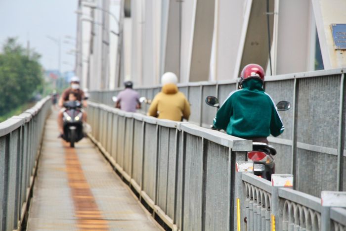 Người đi xe hai bánh nối đuôi nhau qua cầu Ghềnh.