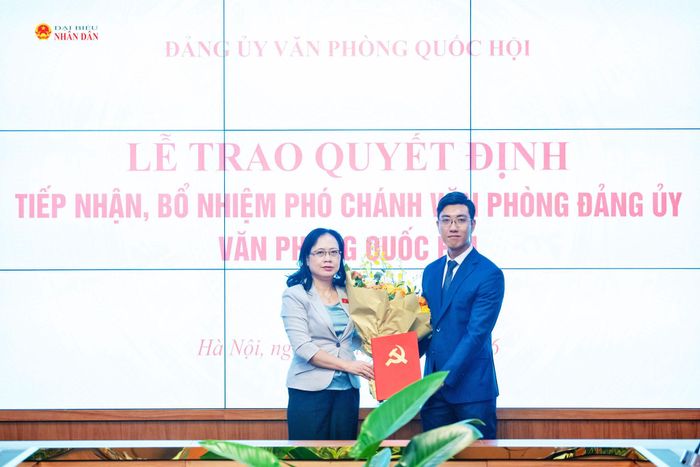 Phó Bí thư Thường trực Đảng ủy Văn phòng Quốc hội, Phó Chủ nhiệm Văn phòng Quốc hội Nguyễn Thị Thúy Ngần trao Quyết định và hoa tặng Phó Chánh Văn phòng Đảng ủy Văn phòng Quốc hội Phan Huy Thành