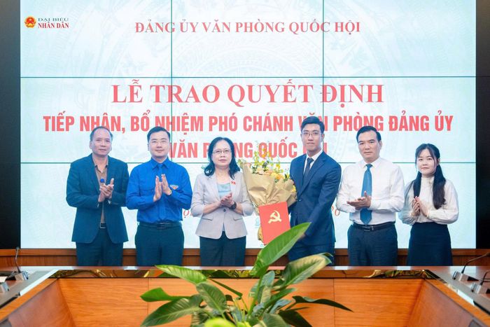 Phó Bí thư Thường trực Đảng ủy Văn phòng Quốc hội, Phó Chủ nhiệm Văn phòng Quốc hội Nguyễn Thị Thúy Ngần trao Quyết định và hoa tặng Phó Chánh Văn phòng Đảng ủy Văn phòng Quốc hội Phan Huy Thành