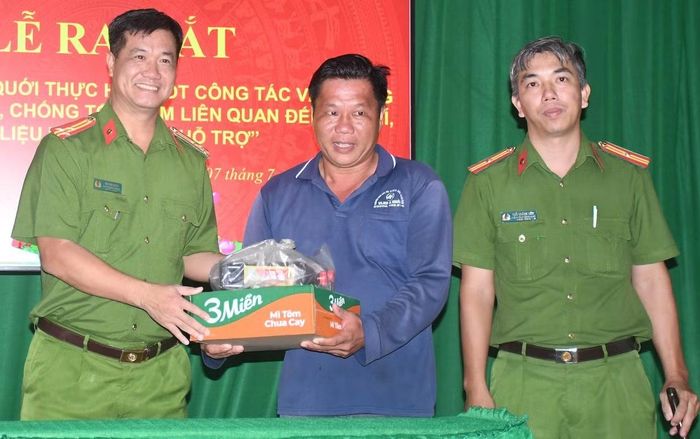 Người dân giao nộp vũ khí và nhận quà từ lực lượng Công an.