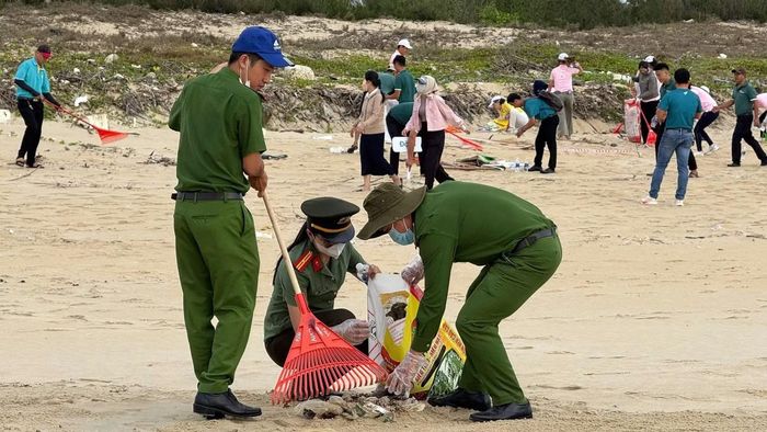 Cán bộ Công an xã Thăng An tham gia thu gom rác, làm sạch bãi biển.