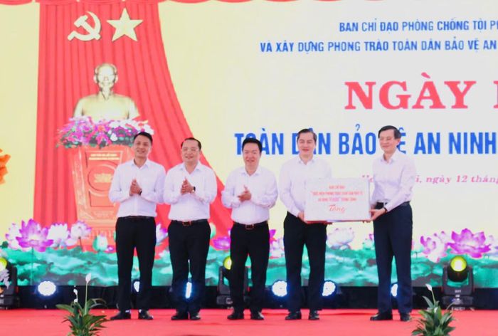  Đồng chí Đoàn Minh Huấn trao quà tặng Đảng bộ, chính quyền và nhân dân phường Hoàng Mai. 