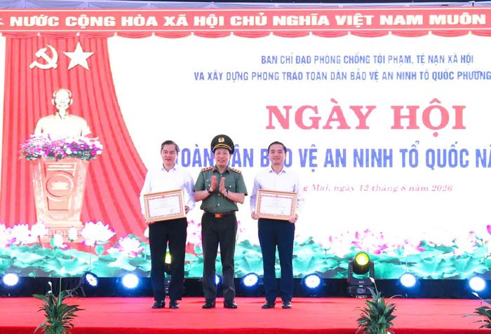 Thượng tướng Lê Văn Tuyến trao Bằng khen của Bộ trưởng Bộ Công an tặng nhân dân, cán bộ phường Vinh Phú và đồng chí Nguyễn Hữu An - Bí thư Đảng ủy phường Hoàng Mai