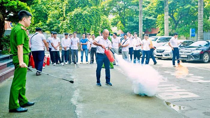 Cán bộ, công nhân viên cơ sở tham gia thực hành sử dụng bình chữa cháy xách tay.