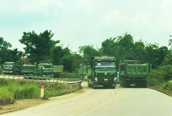 Những xe tải trọng lớn chở vật liệu xây dựng lưu thông trên đường đê thuộc địa bàn xã Hồng Vân. Ảnh: Đỗ Vân