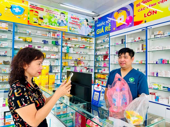 Việc khách hàng chuyển khoản giúp anh Nguyễn Trung Sơn dễ dàng đối soát doanh thu của nhà thuốc vào cuối ca. Ảnh: Trần Oanh.