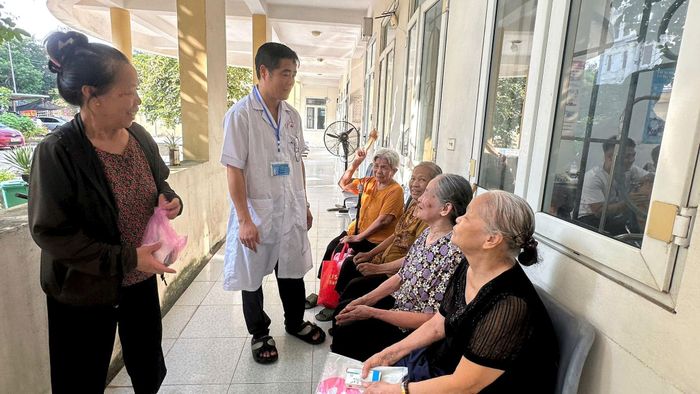 Bác sỹ Nguyễn Hải Kiên phụ trách điểm trạm y tế Tiền Phong, xã Thường Tín hướng dẫn các bệnh nhân cao tuổi chăm sóc sức khỏe bản thân. Ảnh: PV