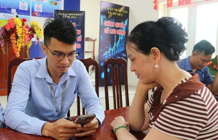 Người dân thôn Phú Cốc, xã Mỹ Đức được hướng dẫn thực hiện chuẩn hóa sim chính chủ. Ảnh: Biên Phạm