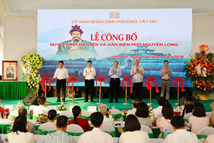 Lãnh đạo phường Tây Hồ, đại biểu cùng đại diện gia đình Võ Phó bảng Nguyễn Long thực hiện nghi thức cắt băng gắn biển tên phố Nguyễn Long. Ảnh: Thu Trang
