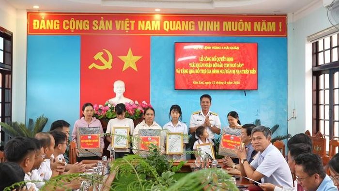 Đại diện Vùng 4 Hải quân trao quà và quyết định nhận đỡ đầu cho ba người con của ngư dân có hoàn cảnh khó khăn. Ảnh: Minh Châu.