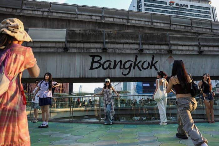  Du khách quốc tế chụp ảnh trên cầu vượt ở Bangkok, Thái Lan, năm 2024. Ảnh: Reuters. 
